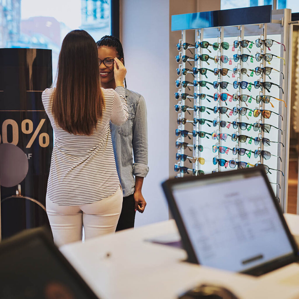 Photo of saleswoman helping a customer who found their eyeglass boutique online via a business directory listing.